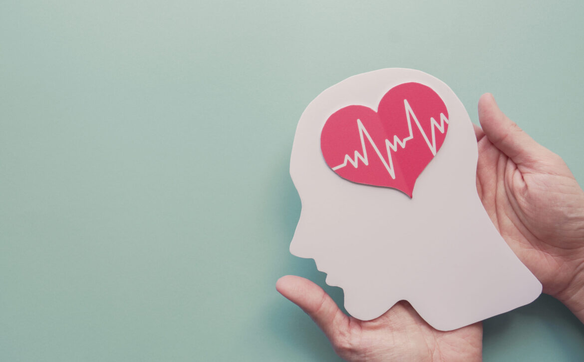 Hands holding paper brain and heart, world heart day, world ment